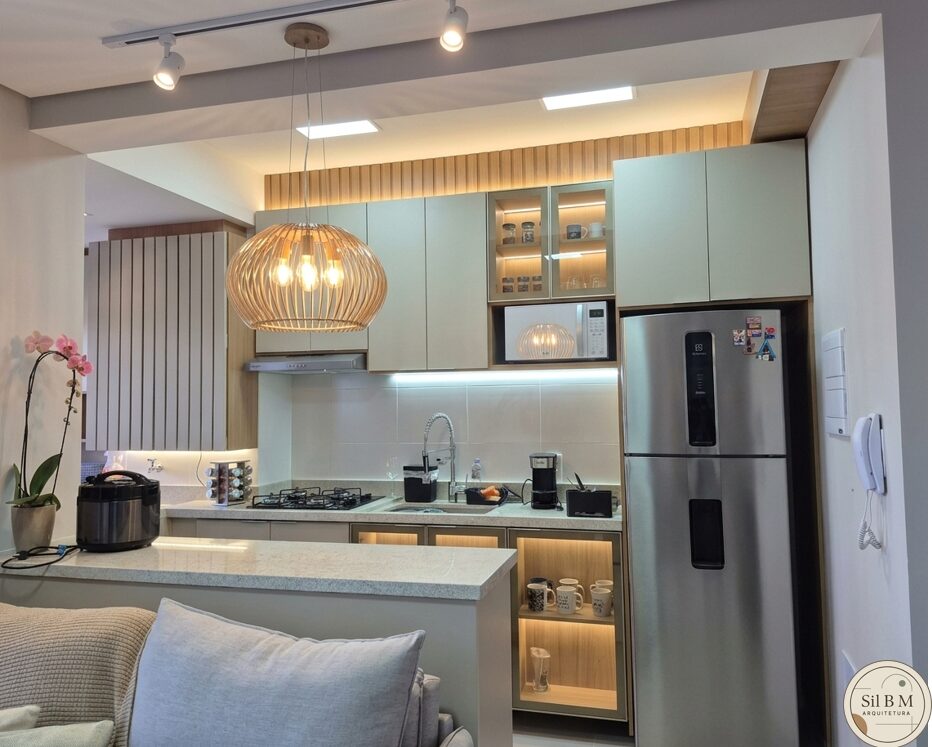 Cozinha planejada com ilha, luminária pendente de fibra natural e eletros em inox
